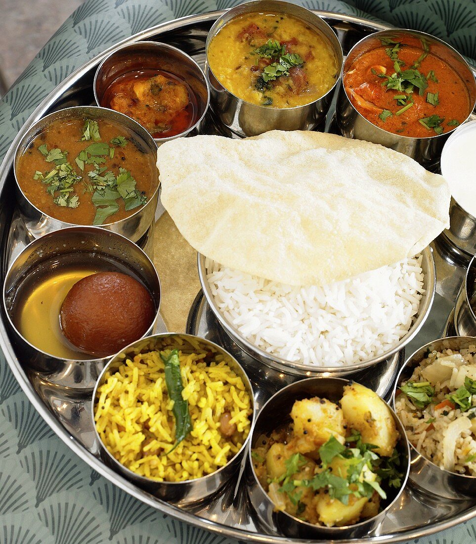 Tray of Assorted Indian Side Dishes with a Bowl of Rice in the Middle