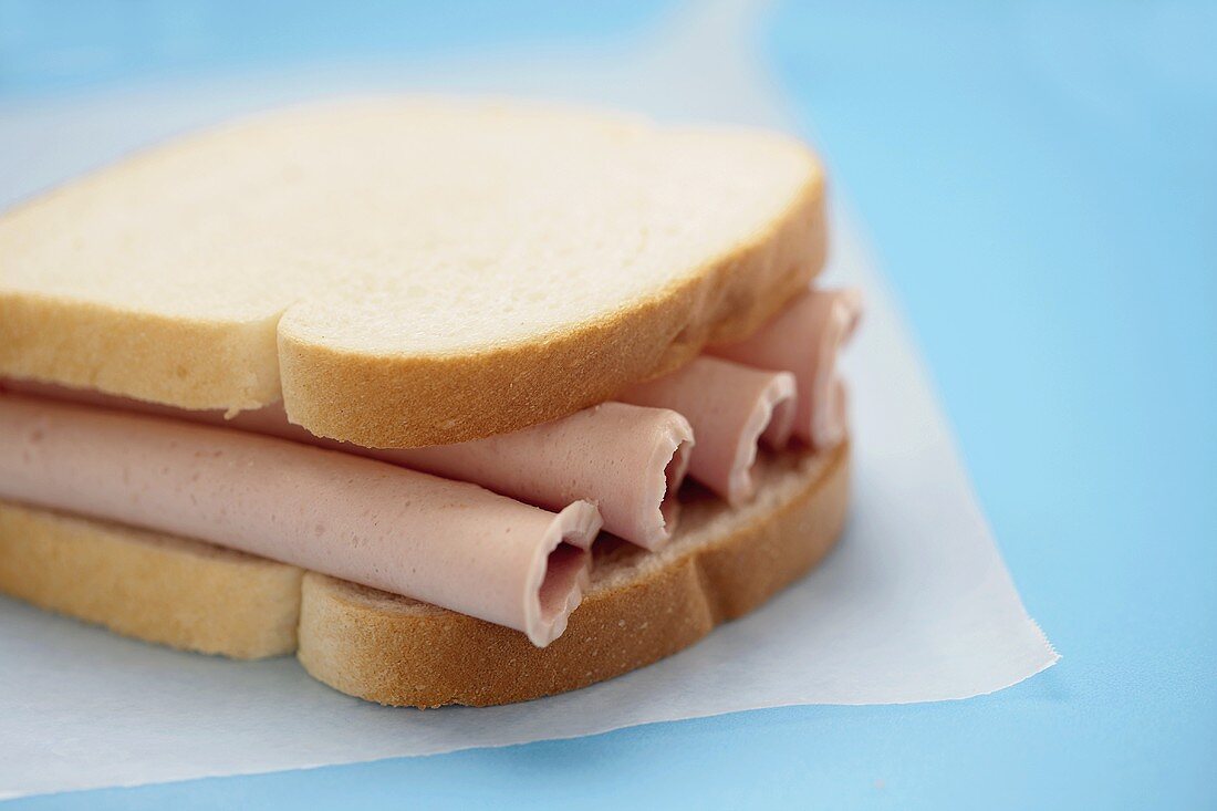 Sandwich mit Wurst auf Butterbrotpapier
