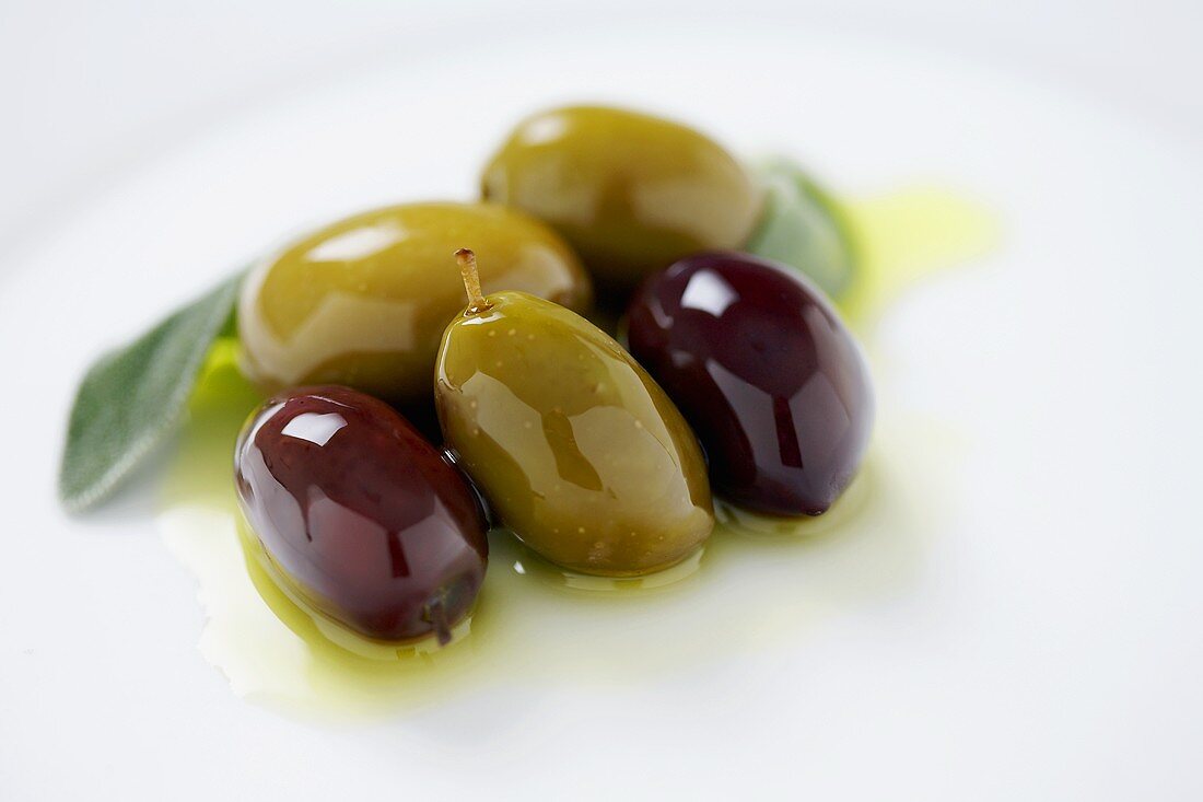 Grüne und schwarze Oliven in Olivenöl