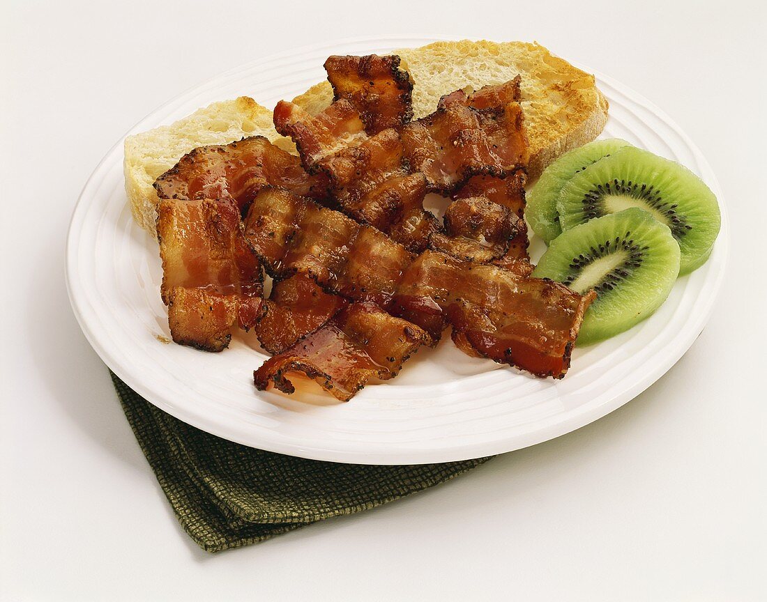 Fried Bacon Strips with Toast and Kiwi Slices