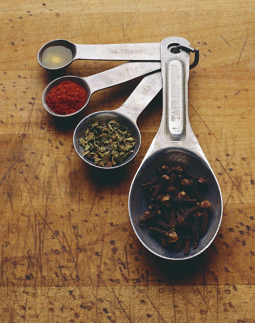 Four Measuring Spoons Filled with Assorted Ingredients