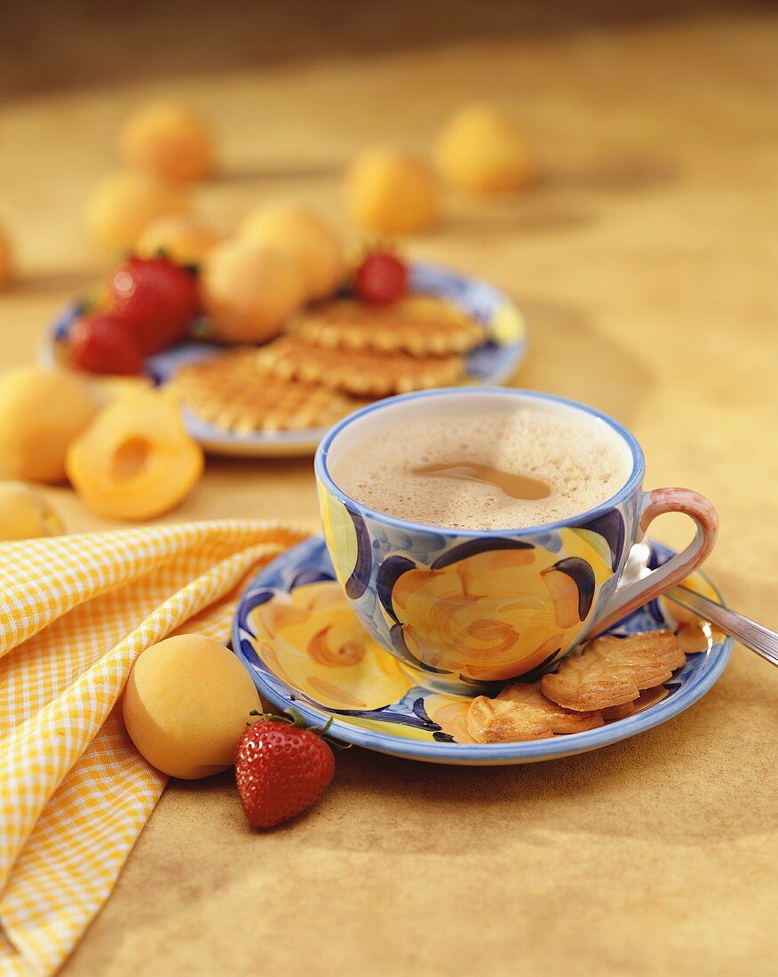 Mug of Cappaccino on a Saucer with Leaf Shaped Cookies; Strawberry and Apricot