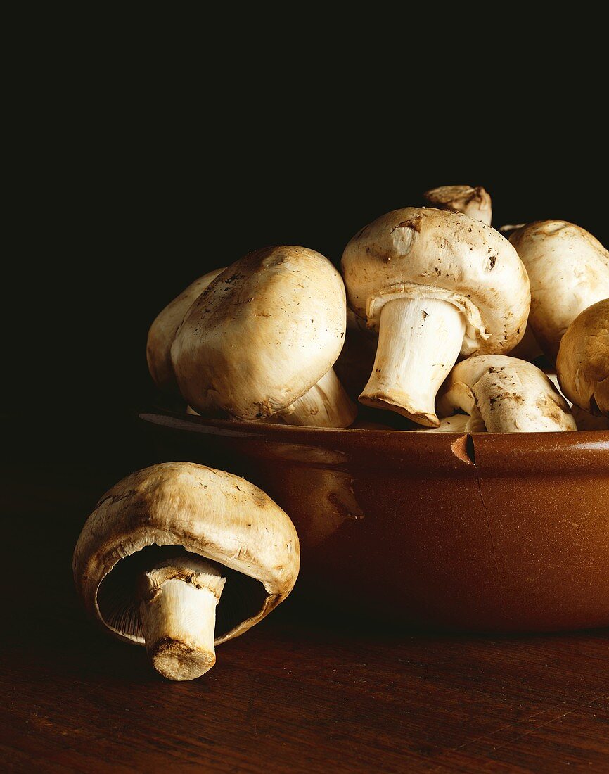 Button Mushrooms in and Beside a Chipped Bowl
