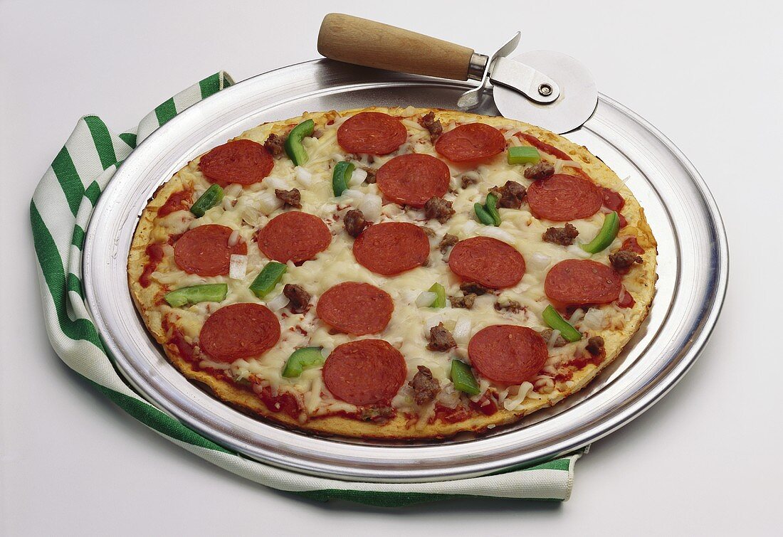 A Pepperoni, Sausage, Pepper and Onion Pizza on a Pizza Pan with Cutter
