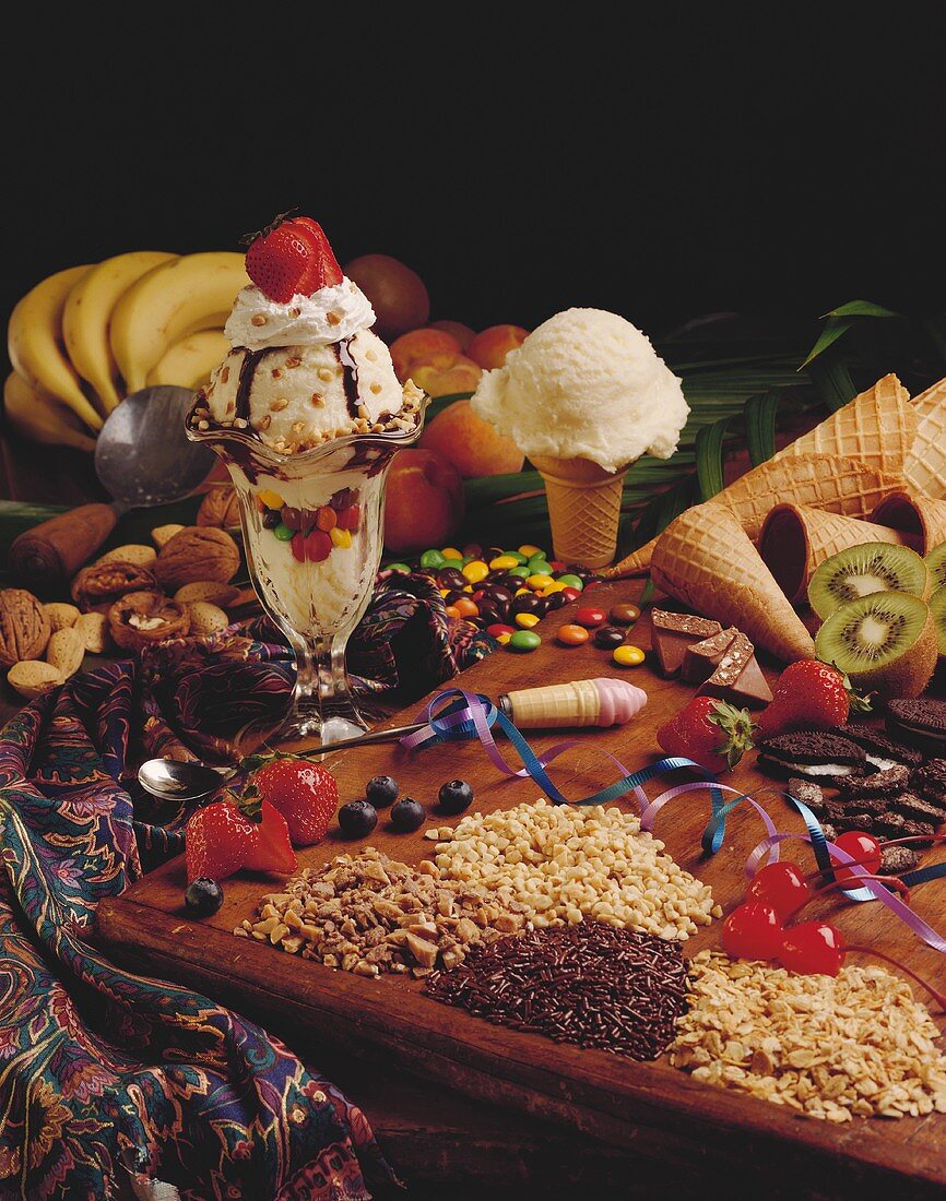 A Vanilla Ice Cream Cone and a Sundae Surrounded by Various Toppings