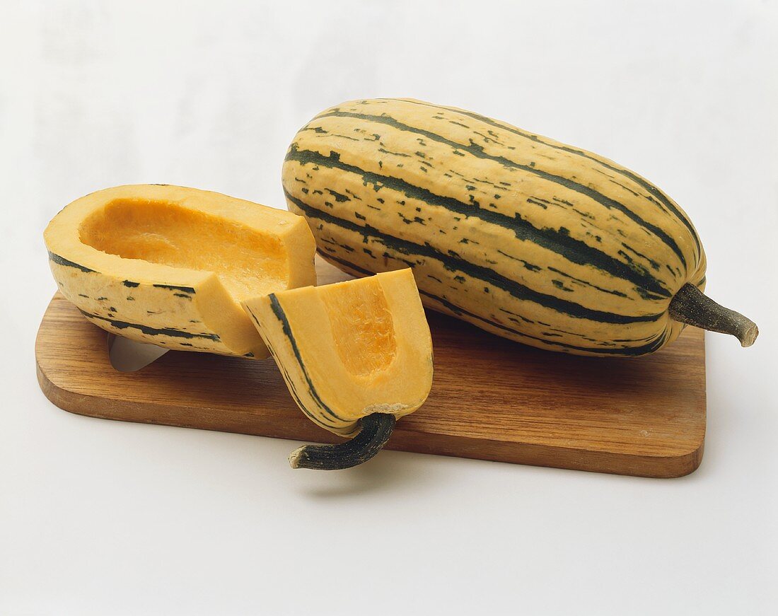 Delicata Squash on a Wooden Board: Halved and Whole