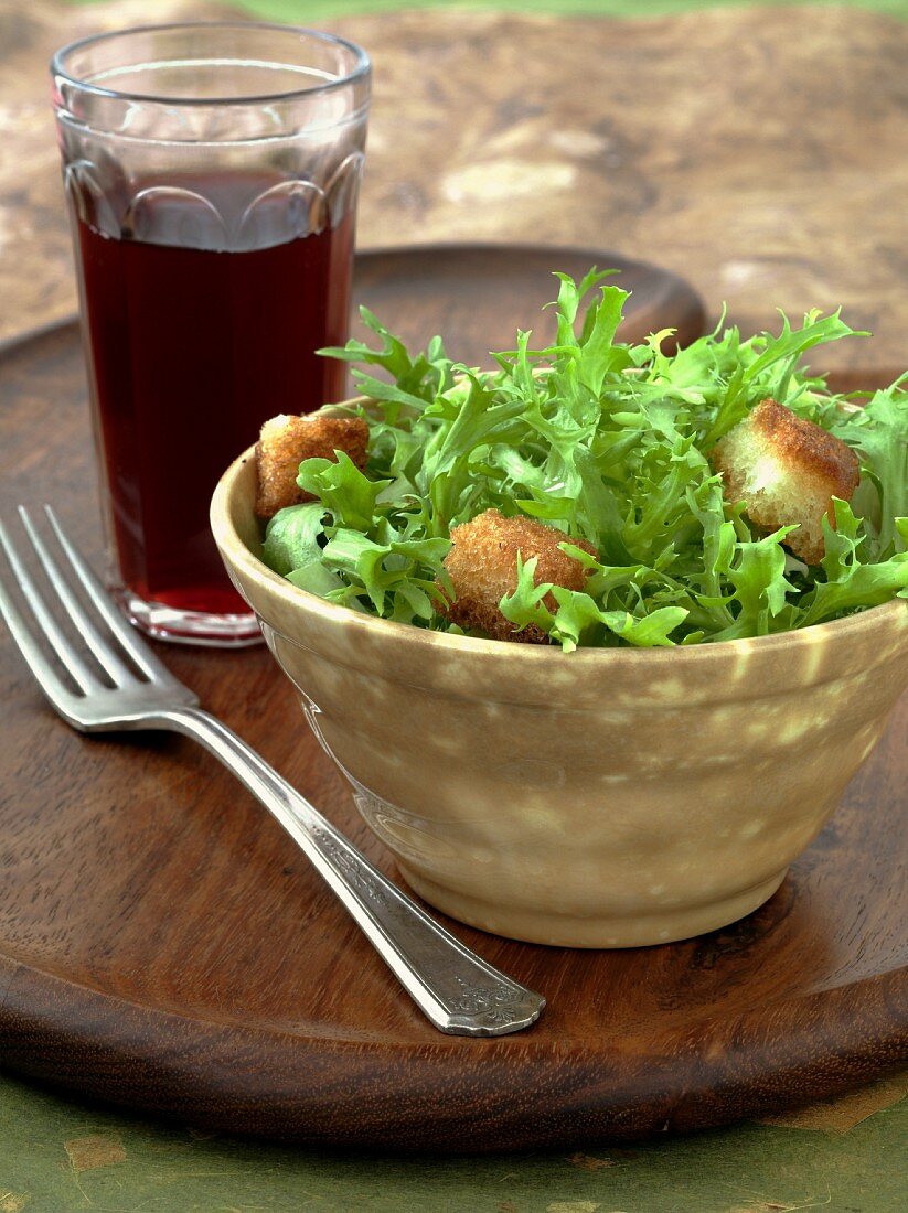 Bowl of Frisee Salad with Croutons, Glass of Ice Tea