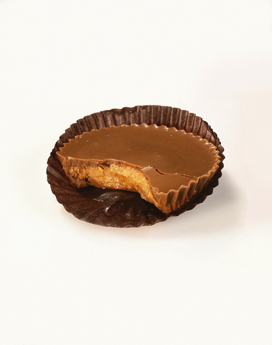 A Peanut Butter Cup with a Bite Taken Out on a White Background
