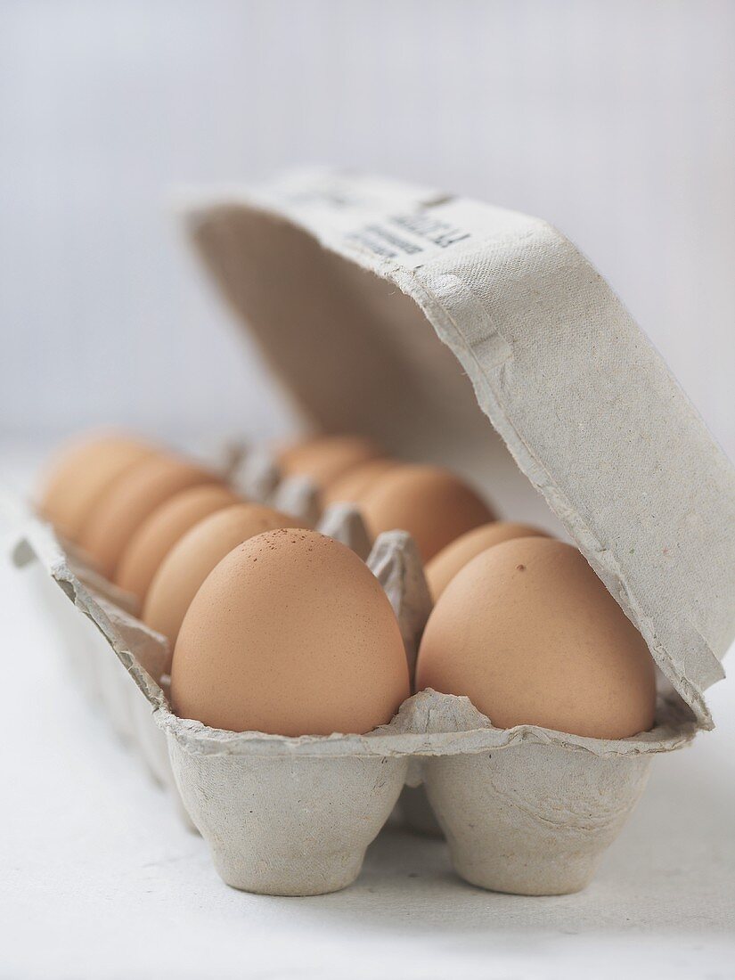 A Dozen Brown Eggs in a Cardboard Carton