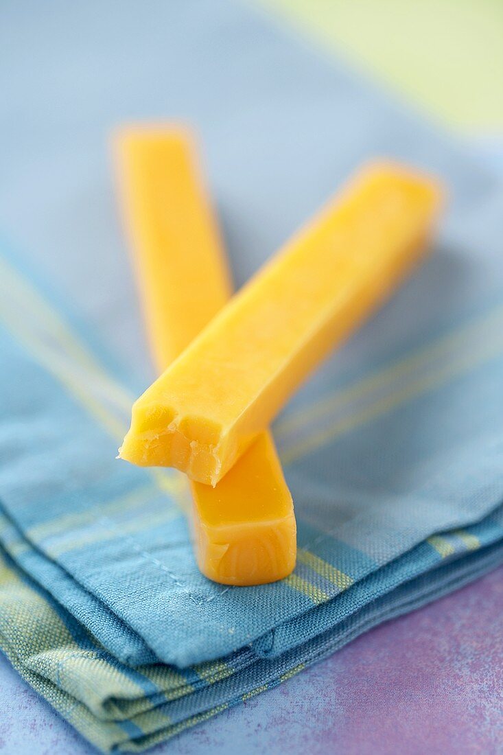 Two Cheddar Cheese Sticks, One Bitten