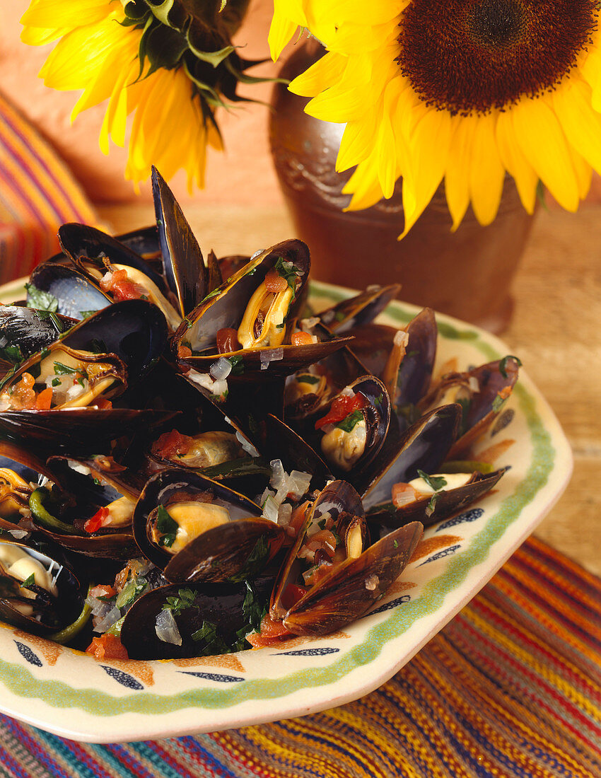 Steamed Mussels Next to a Vase of Sunflowers