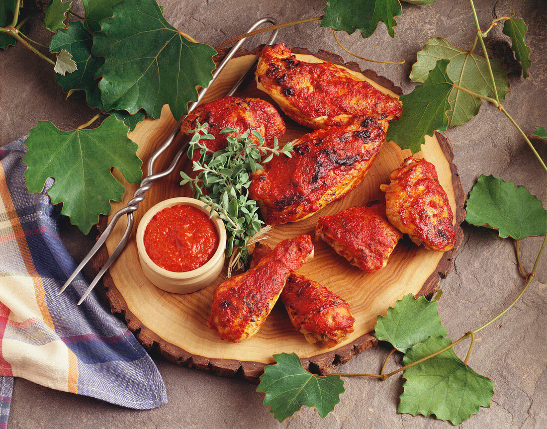 Wooden Platter of Grilled Barbecued Chicken with Small Bowl Of Barbecue Sauce