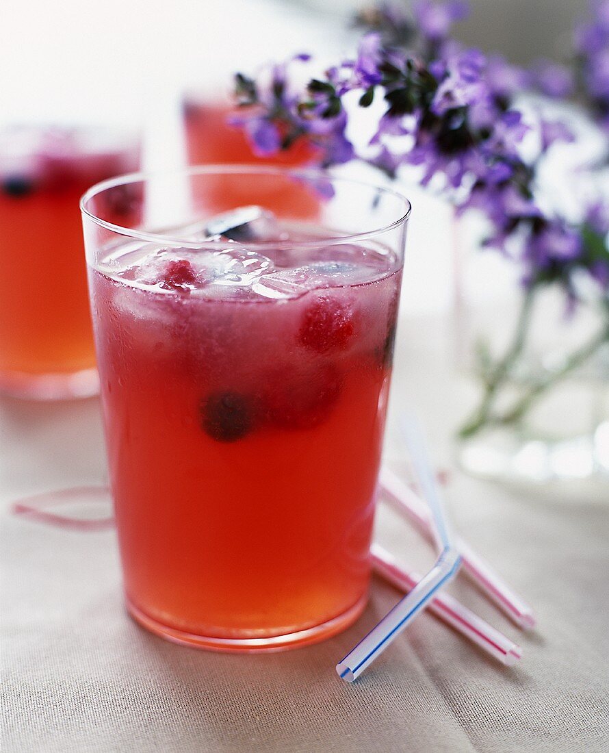 Rosa Limonade mit Beeren und Eiswürfeln