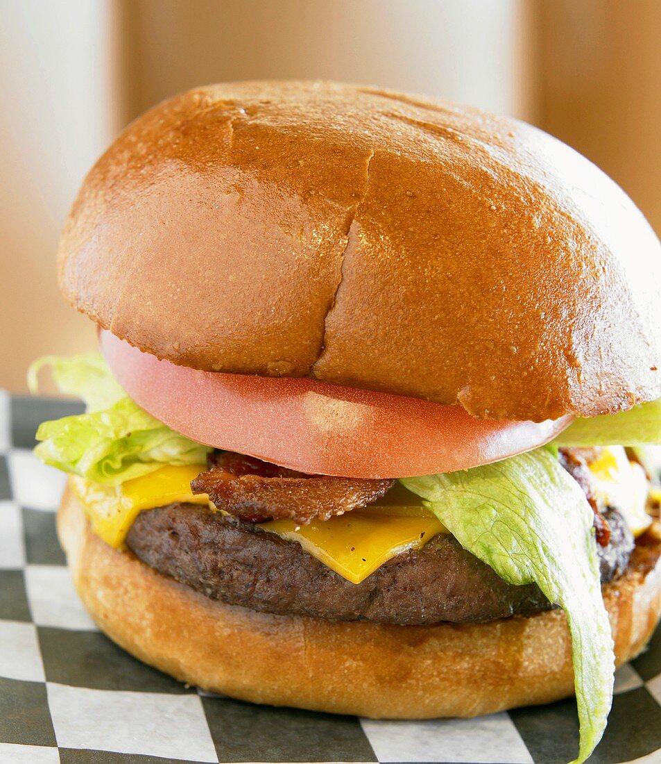 Cheeseburger mit Bacon, Tomate und Salatblatt