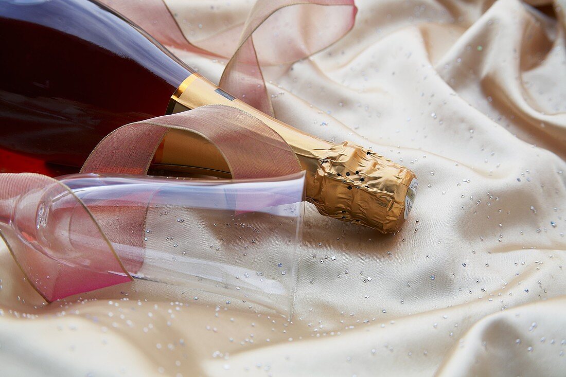A Bottle of Champagne with Champagne Flute and Riboon Satin