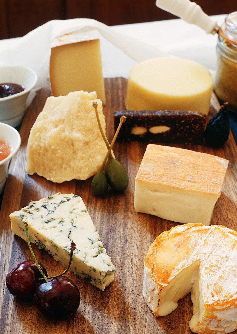 Cheese and Fruit Still Life on a Wooden Board