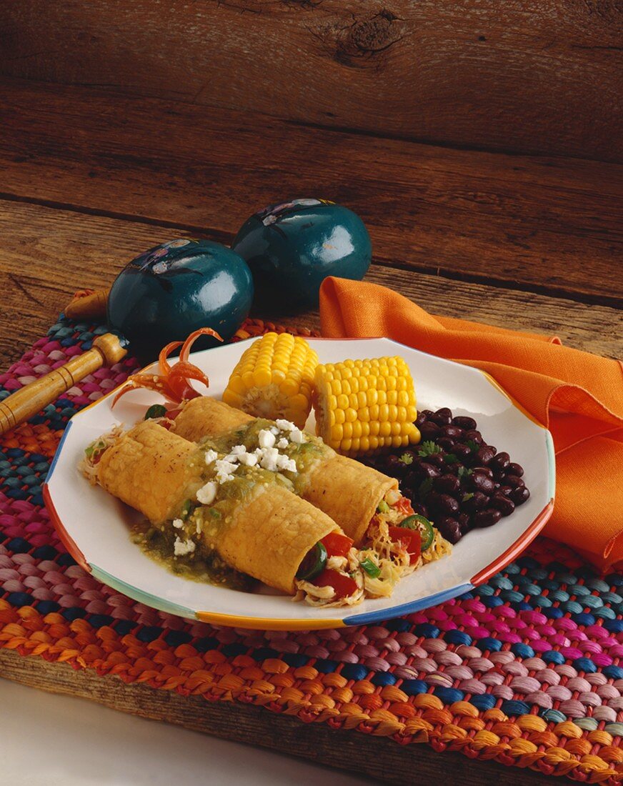 Plate of Chicken Enchiladas with Salsa Verde, Black Beans and Corn on the Cob
