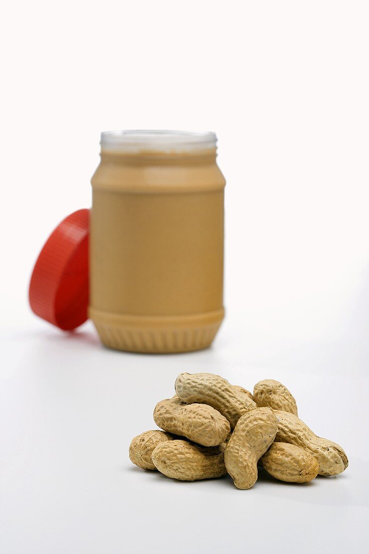 Pile of Whole Peanuts, Jar of Peanut Butter