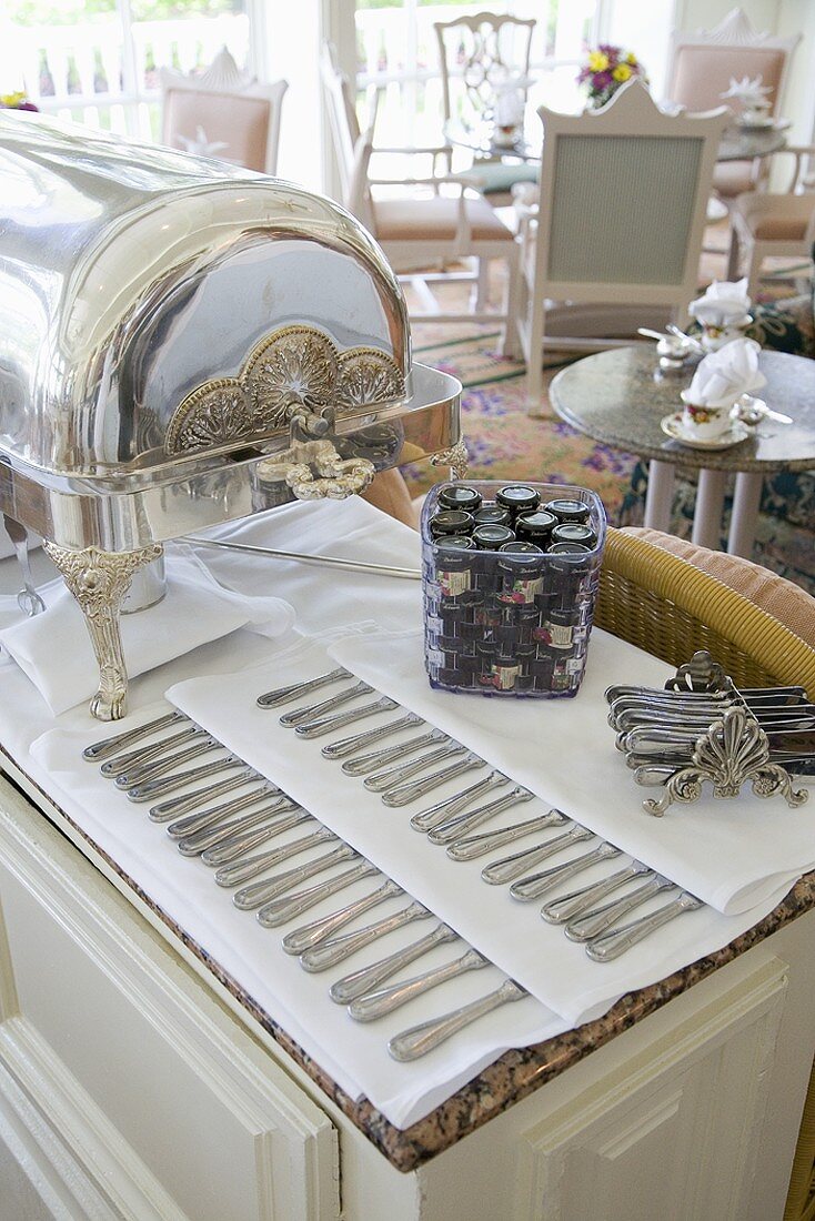 Buffet Table Laid with Silver Chafing Dish, Flatware and Preserves for High Tea