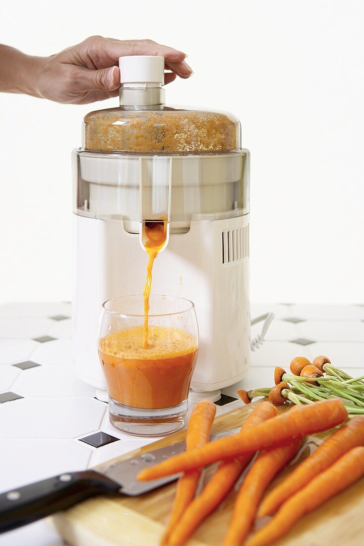 Hand Pressing Juicer to Make Carrot Juice, Fresh Carrots
