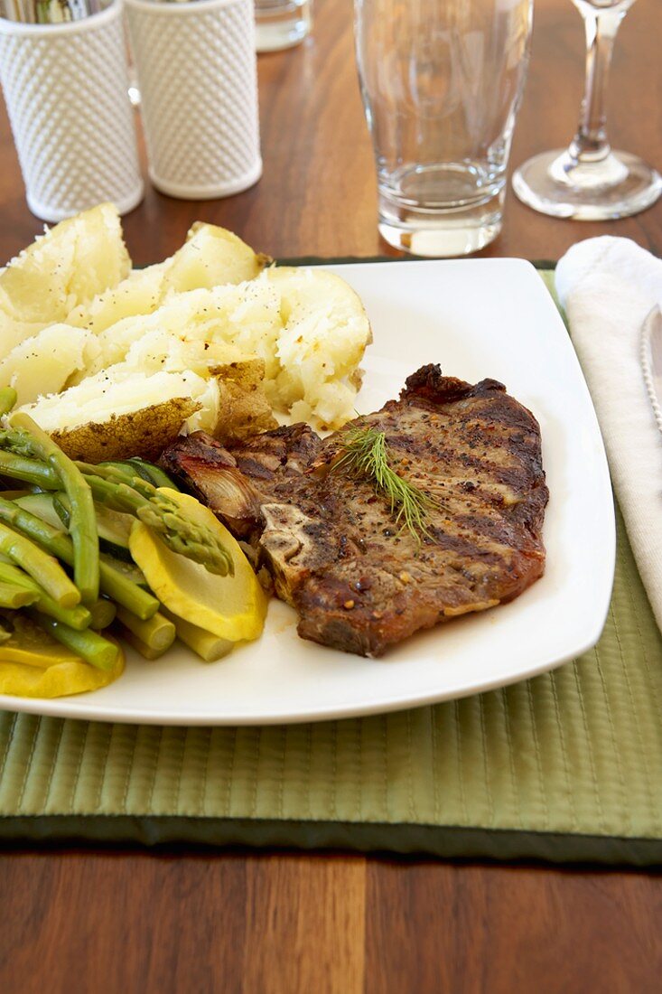 Grilled T-Bone Steak with Baked Potato, Asparagus and Yellow Squash