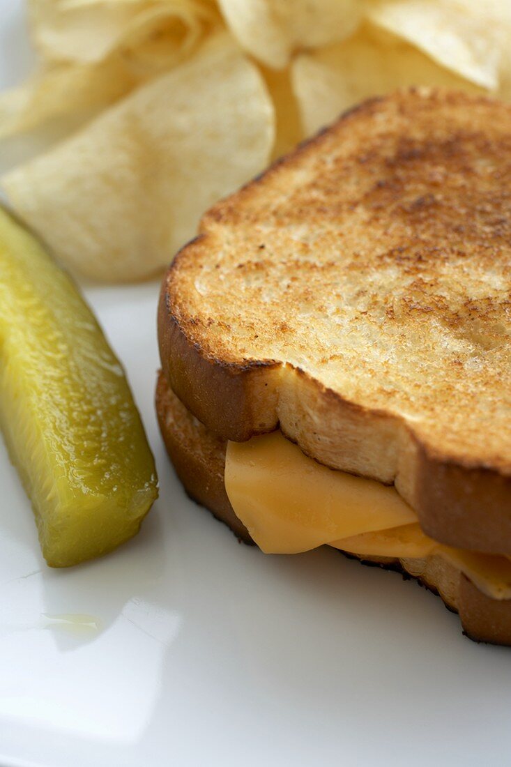Grilled Cheese Sandwich with a Pickle and Chips