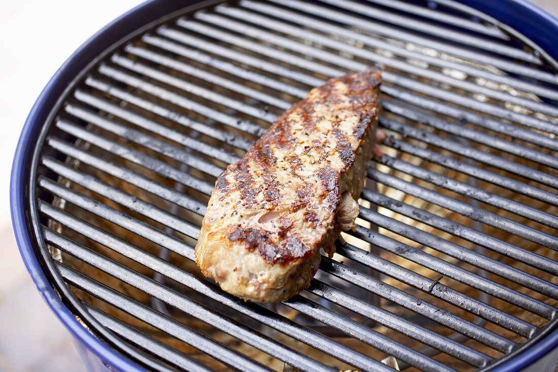 Top Sirloin Steak Cooking on Charcoal Grill