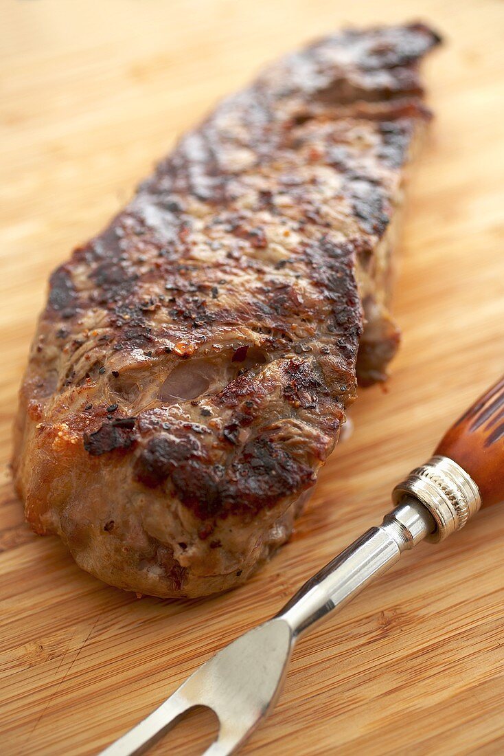 Gegrilltes Sirloin Steak auf Schneidebrett mit Fleischgabel