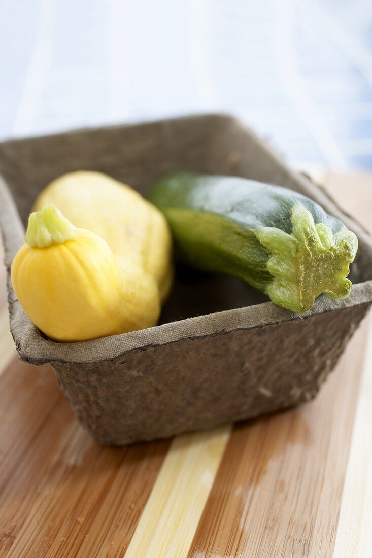 Gelber Kürbis und Zucchini in Behälter