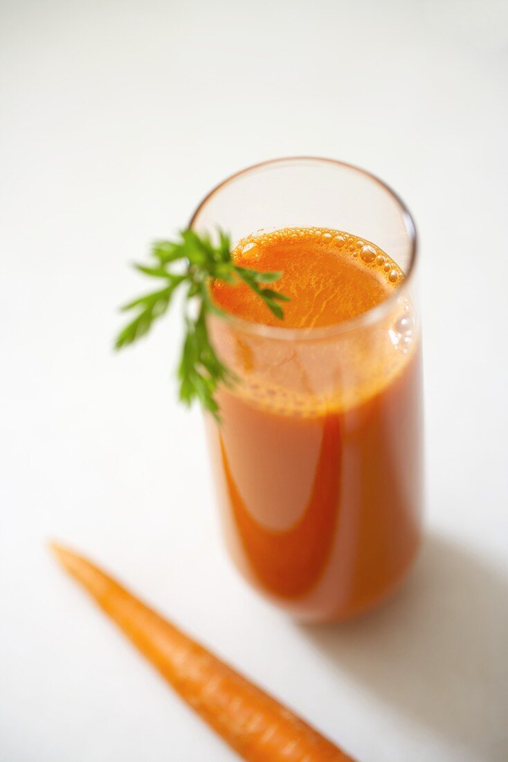 Glass of Organic Carrot Juice with a Carrot