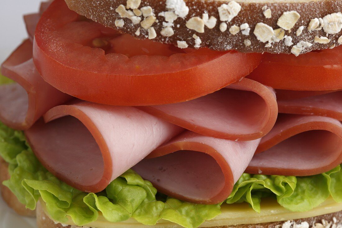 Close Up of a Ham and Tomato Sandwich with Lettuce and Cheese