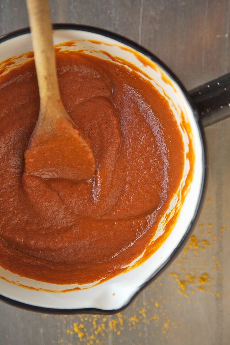 Sauce Marinara im Kochtopf mit Kochlöffel (Draufsicht)