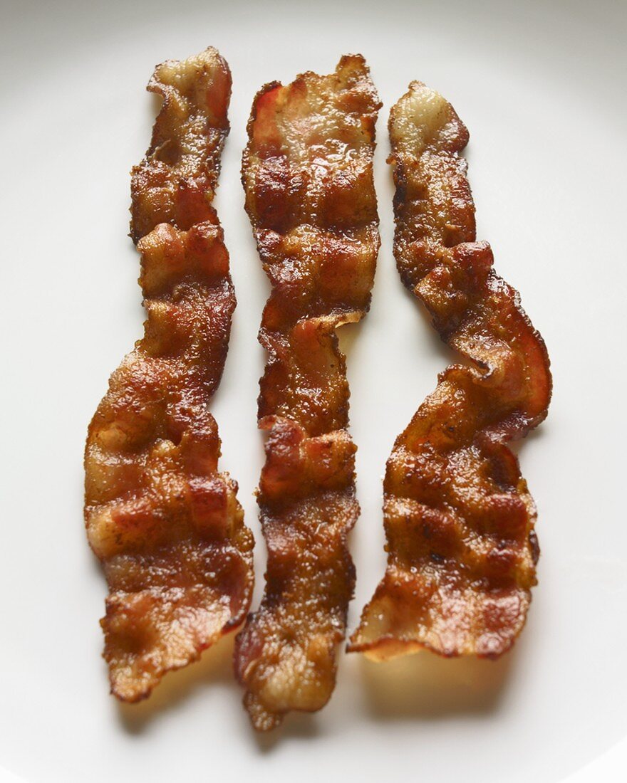 Three Crispy Strips of Bacon on a White Background