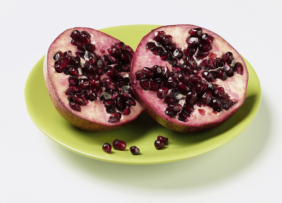 Pomegranate Cut in Half on a Green Plate