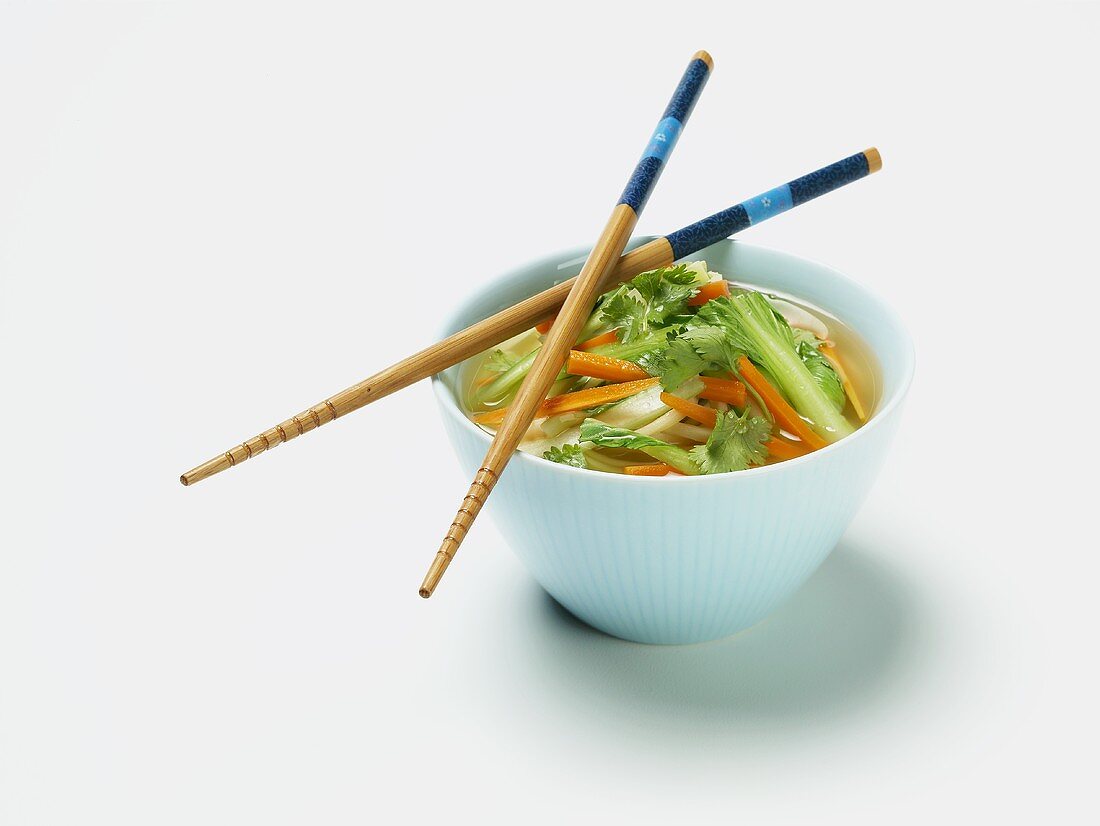 Asiatische Gemüsesuppe im Schälchen mit Essstäbchen