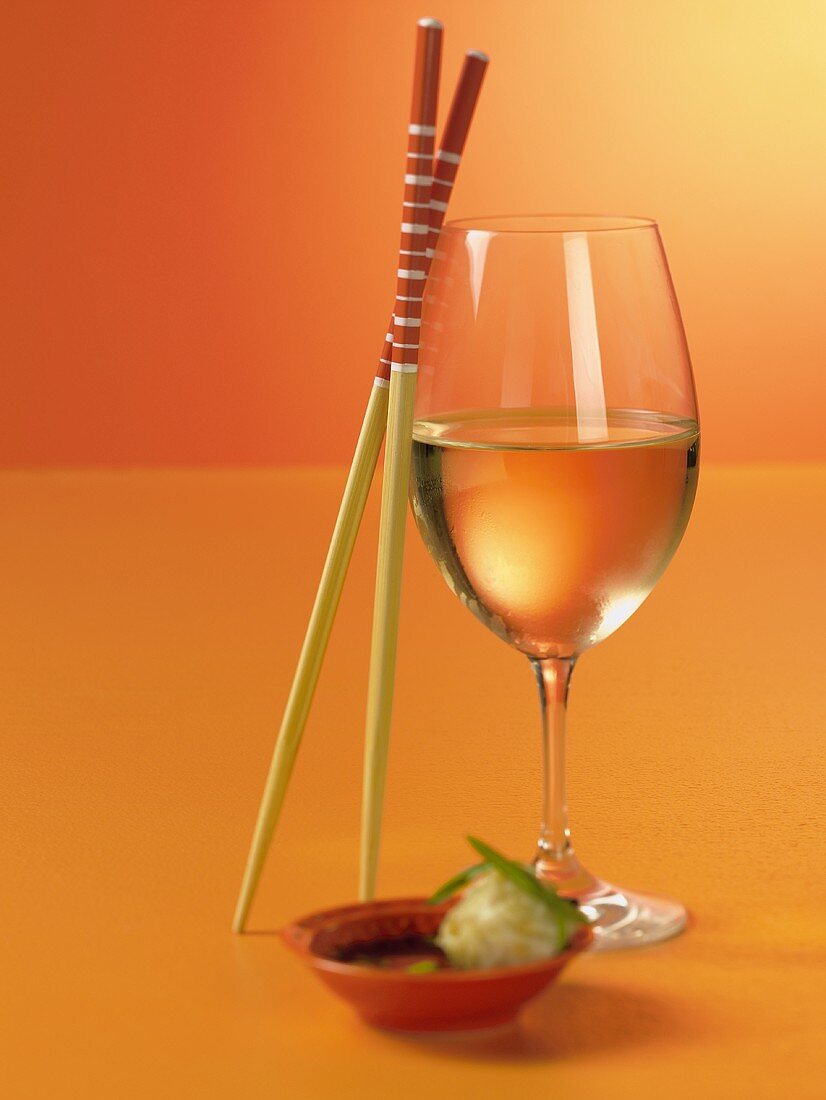 Weißwein im Glas, Essstäbchen & Häppchen in Schale