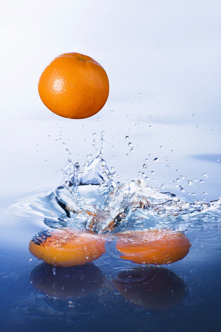 Oranges falling into water
