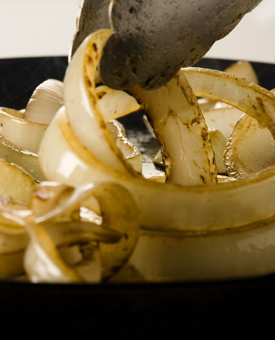 Onion rings being fried in a pan (close up)