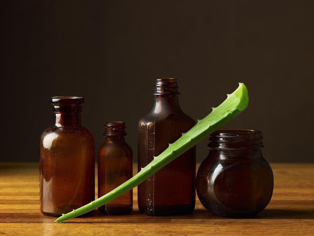 Aloe-Vera-Blatt und Apothekerflaschen