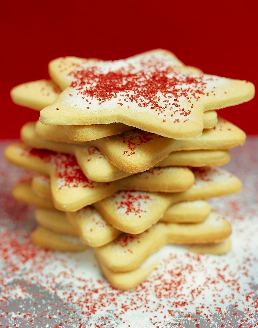 Star biscuits with icing and red sprinkles, in a pile