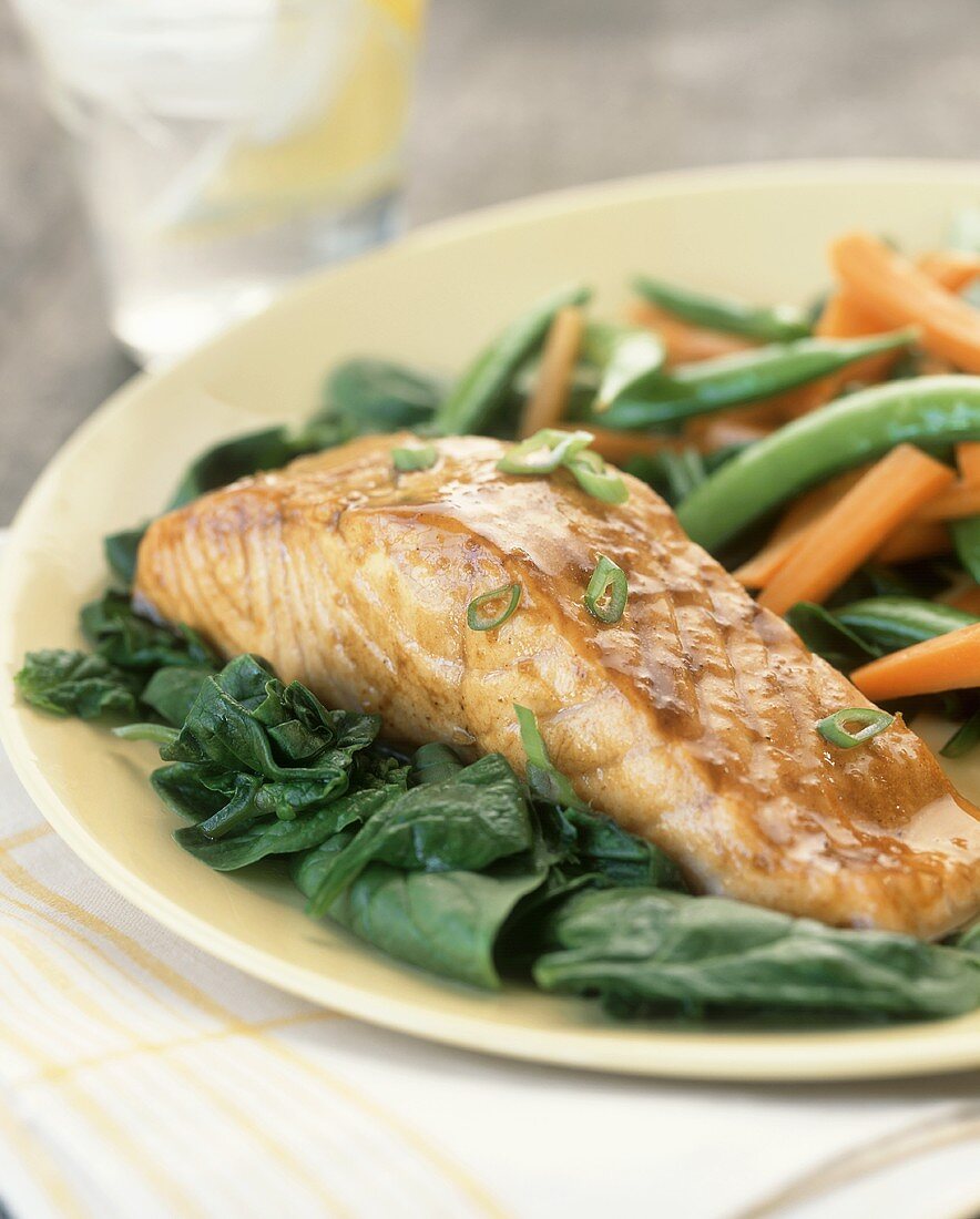 Salmon fillet on spinach with sugar snap peas and carrots