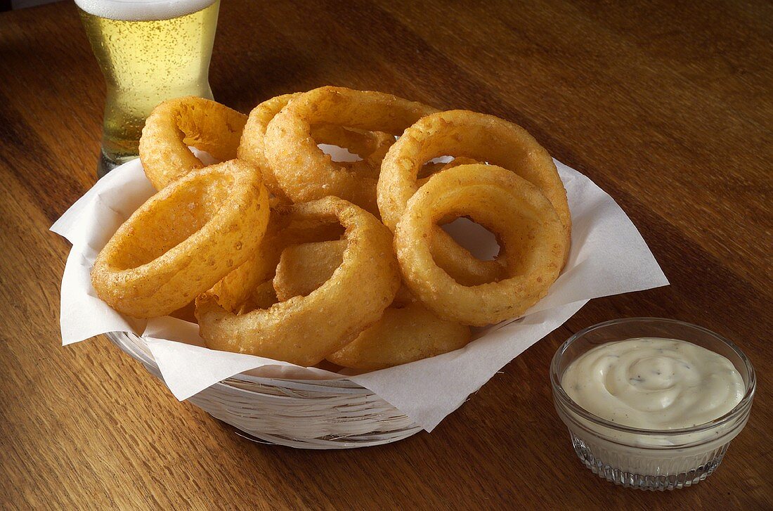 Frittierte Zwiebelringe mit Dip und Bier