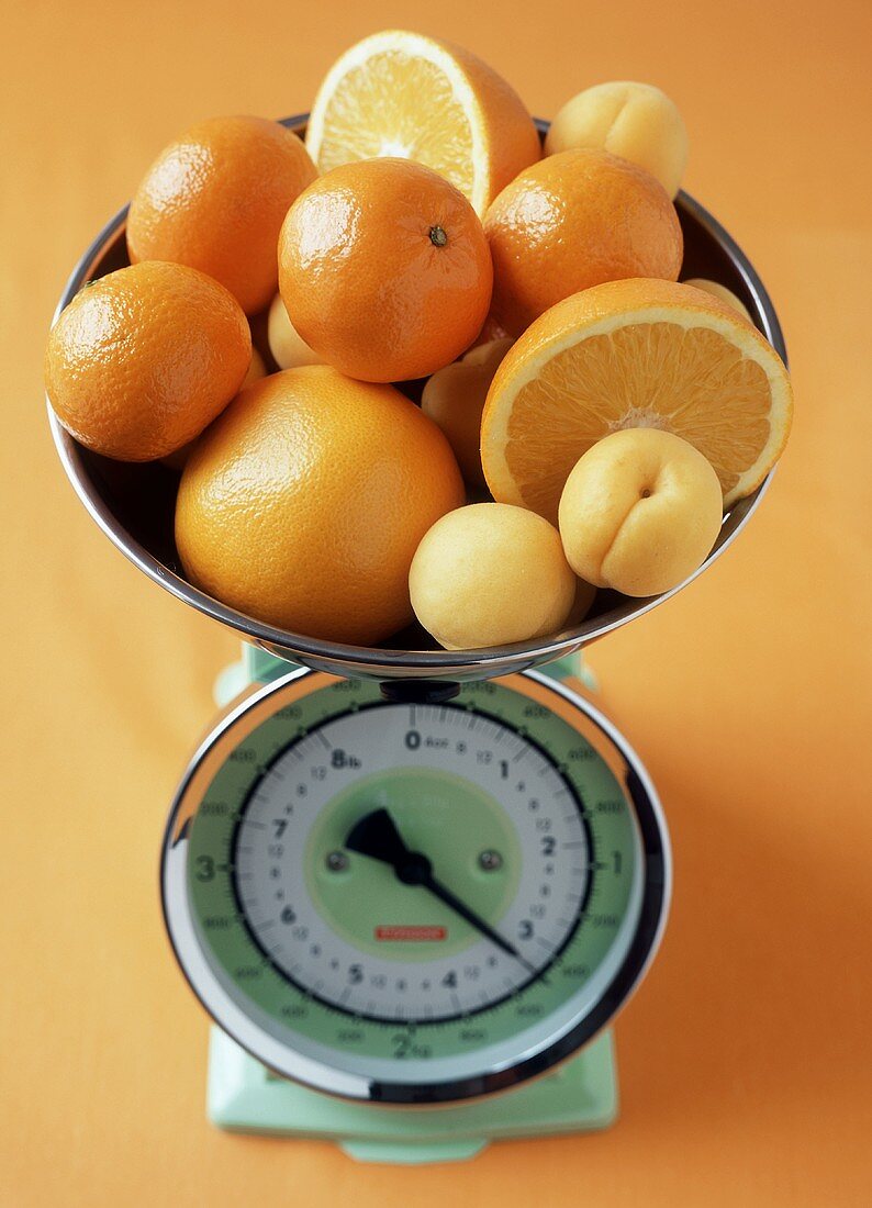 Citrus fruits and apricots on scales