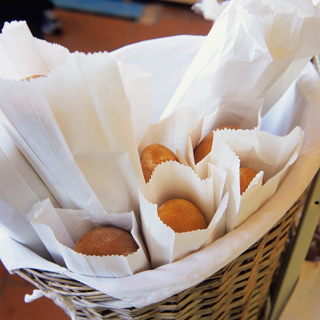 Fresh Baked Bread in Paper Bags in a Large Basket
