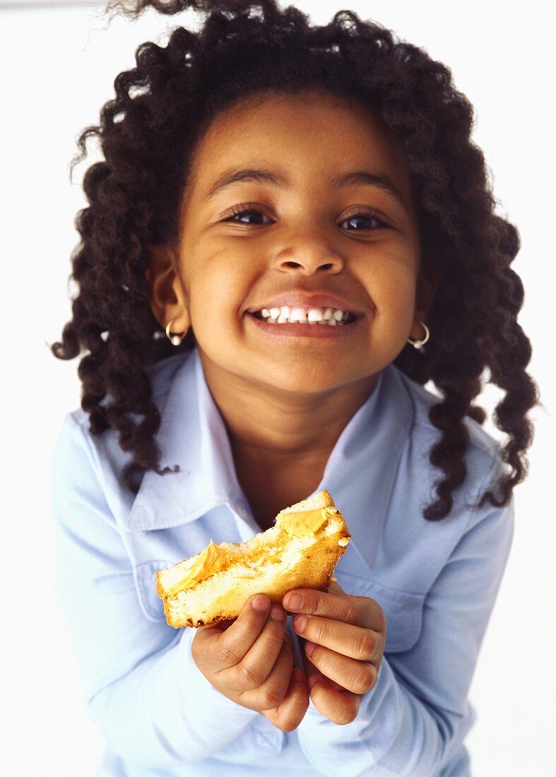 Mädchen hält Toast mit Erdnussbutter