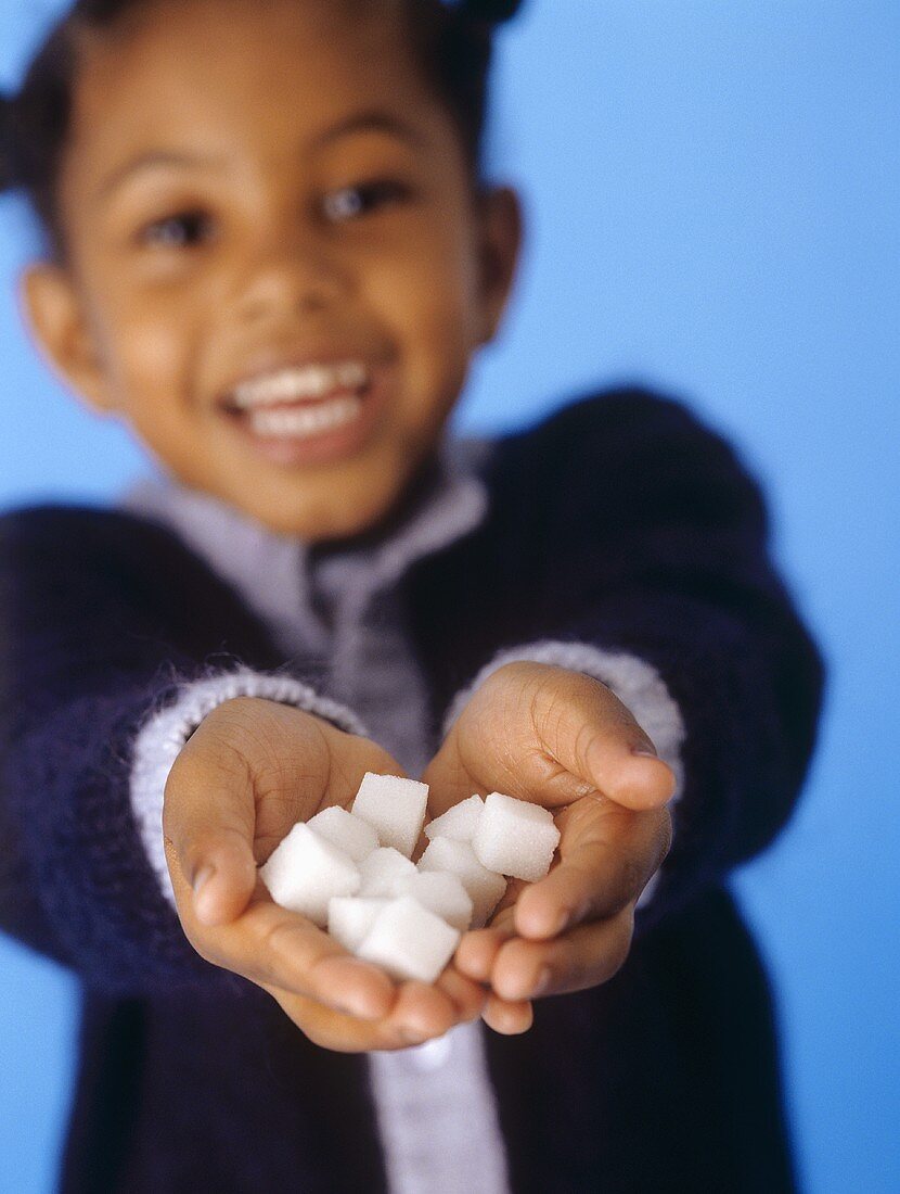 Girl holding sugar lumps in her hand