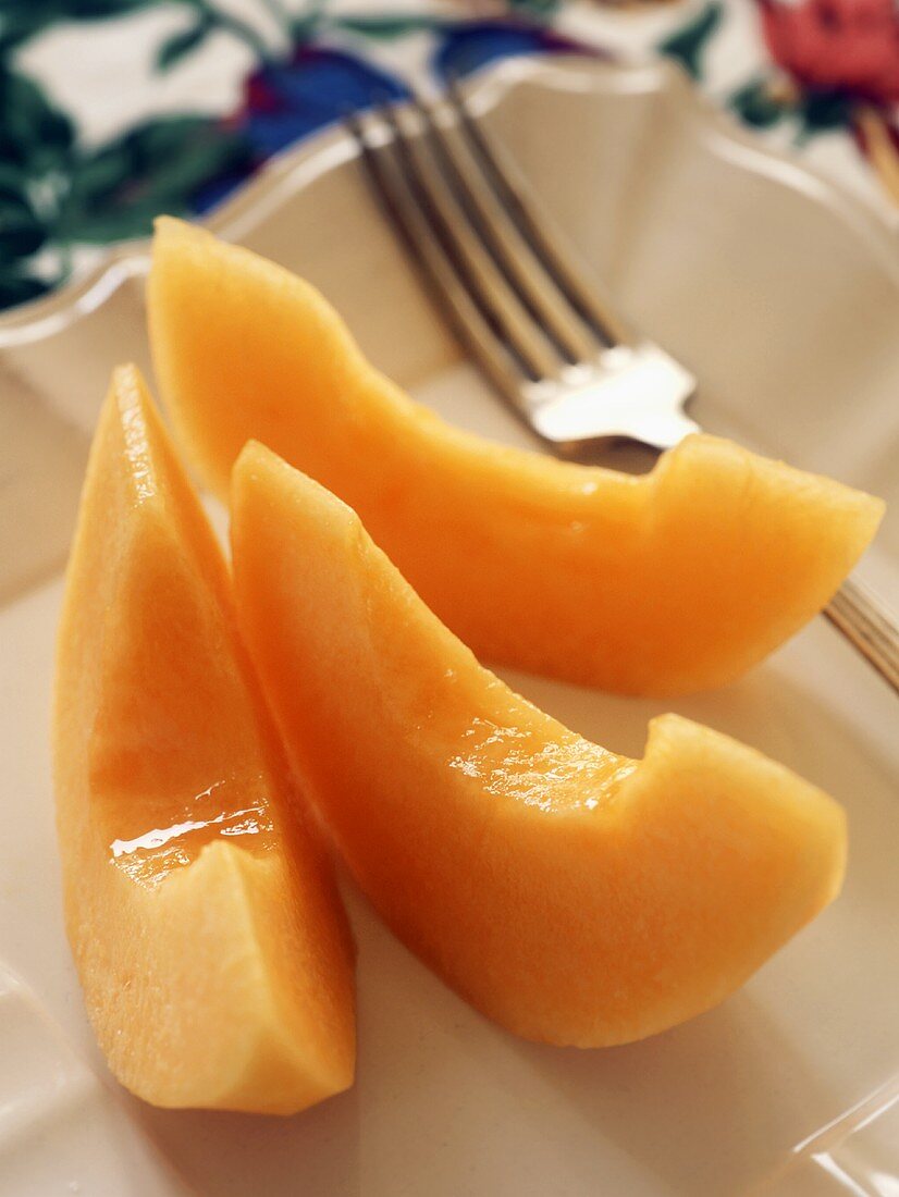 Three slices of sweet melon on plate