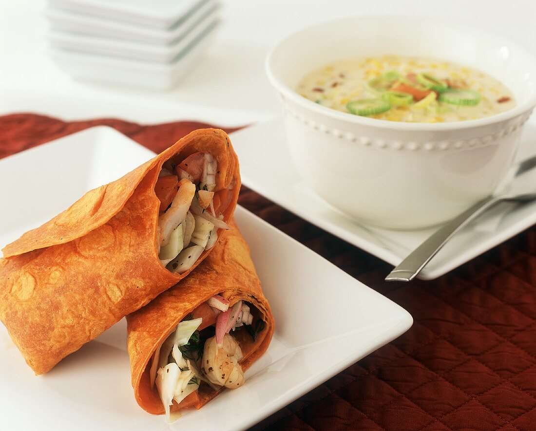 Warm Shrimp Salad Wrapped in a Tomato Wrap; Halved; Bowl of Corn Soup
