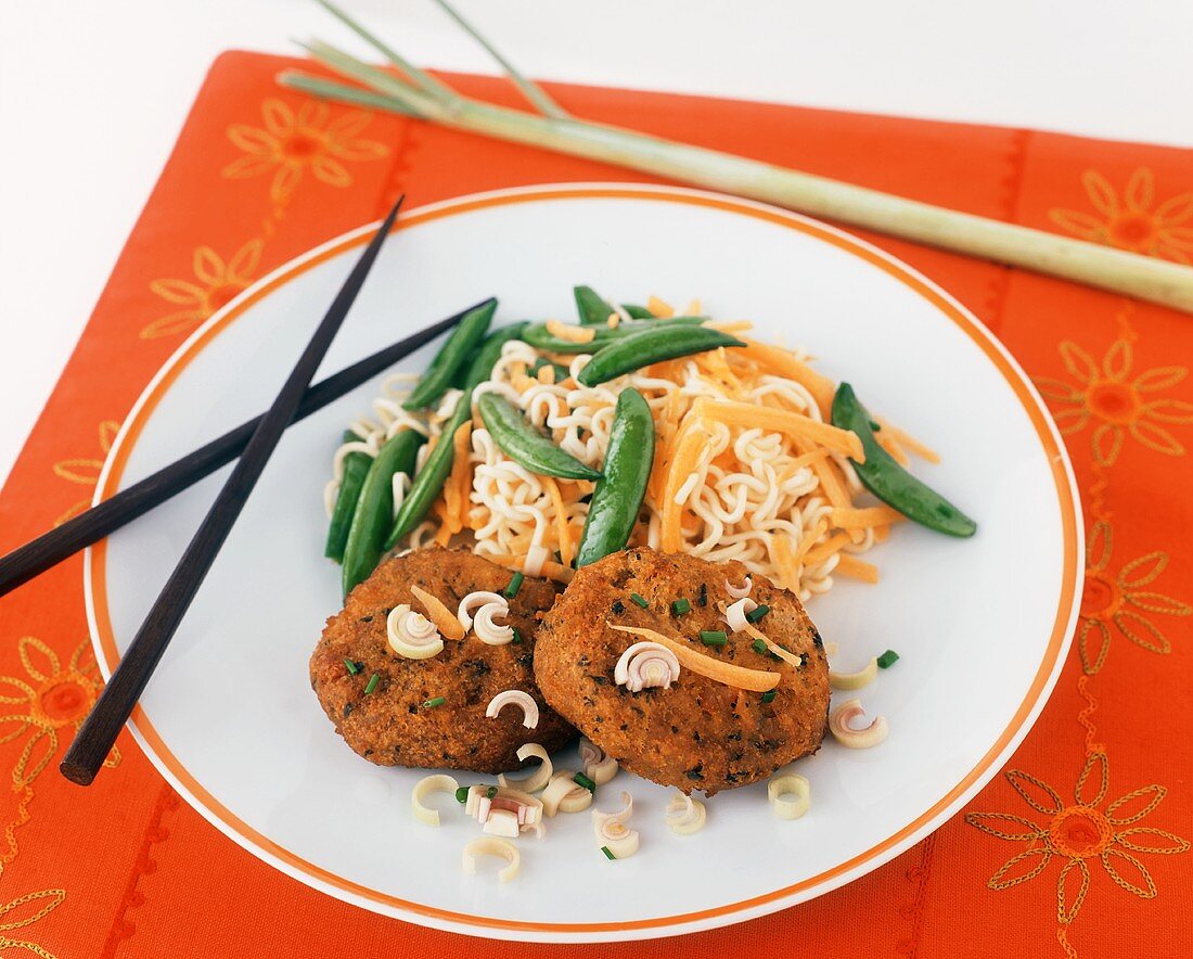 Sambal Salmon Cakes with Asian Noodles, Carrots and Pea Pods on a Plate with Chopsticks