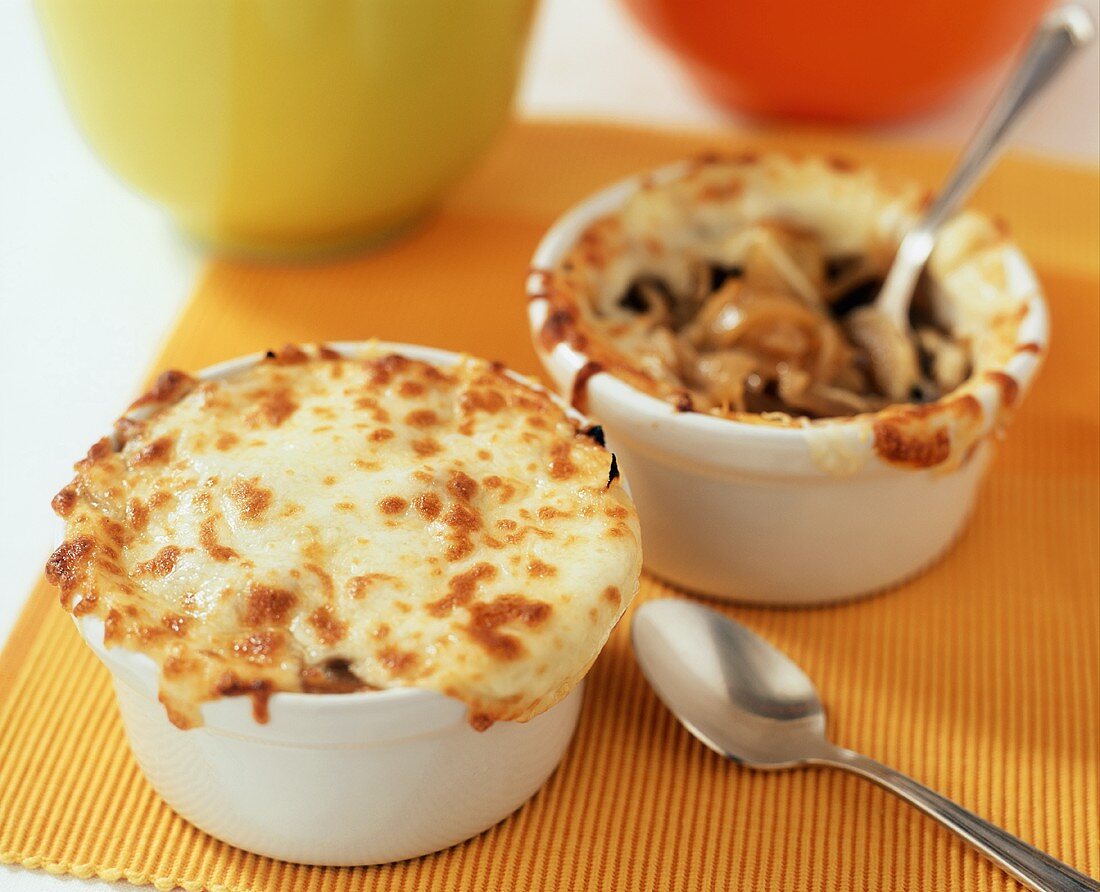 Two bowls of onion soup with cheese topping
